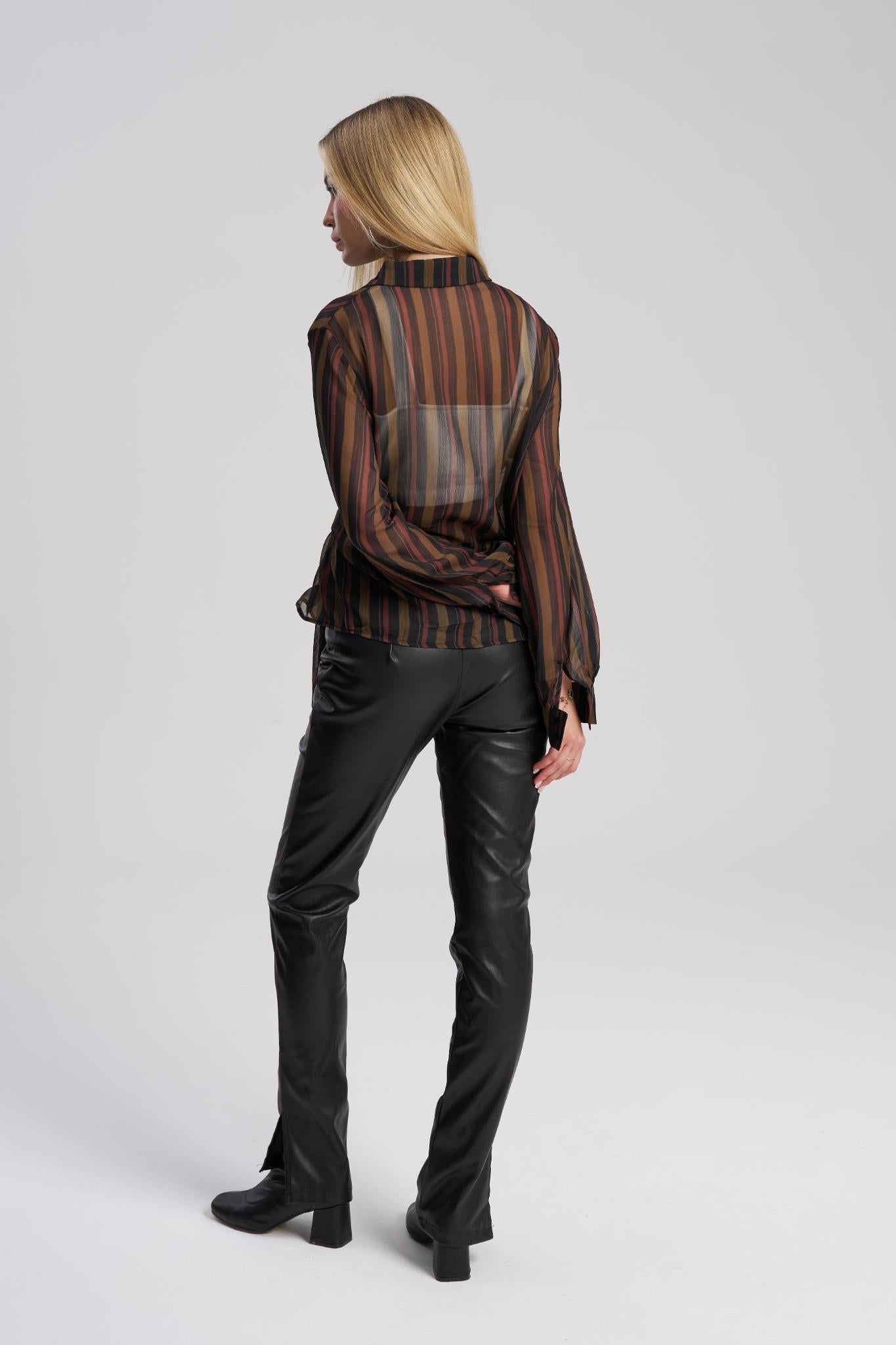 Woman wearing a striped shirt and black leather pants on a white background