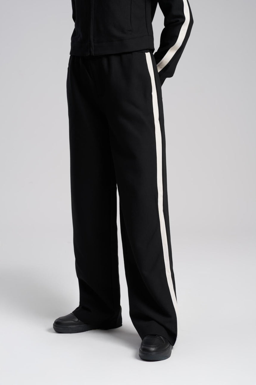 Black tracksuit with white stripes on a gray background