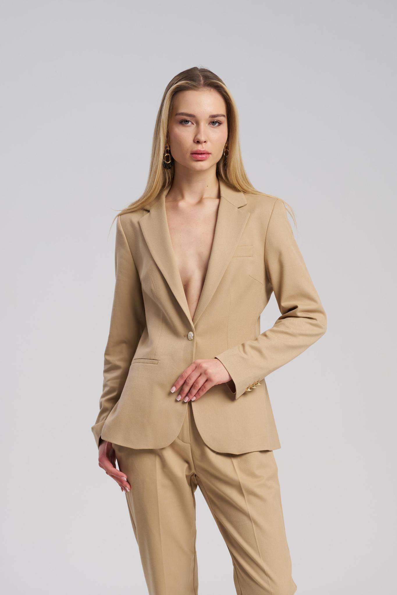 Woman wearing a beige suit on a plain background