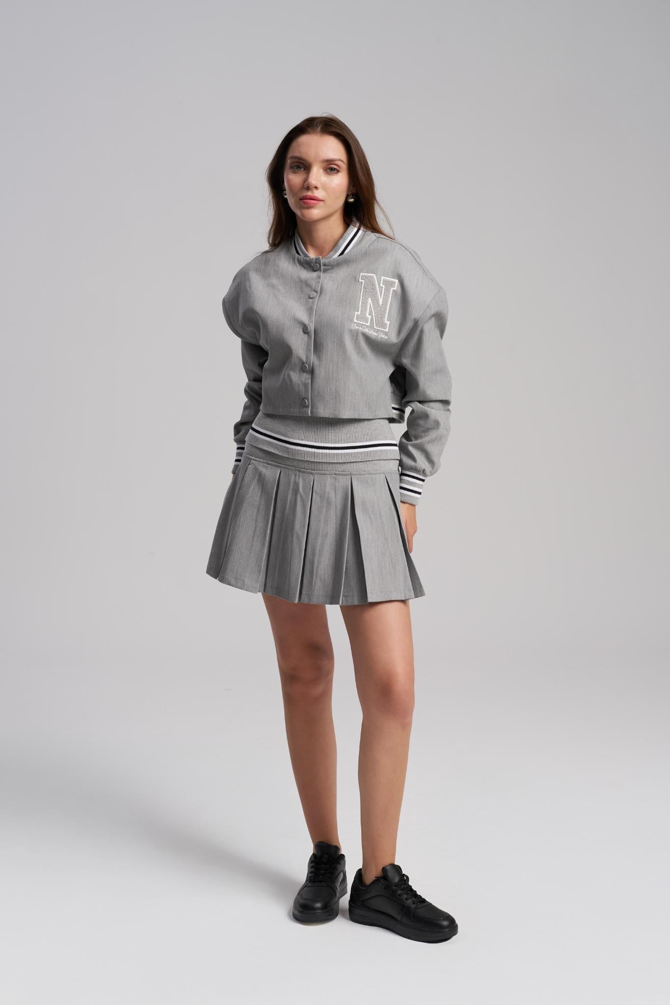 Woman wearing a gray tracksuit with a logo on a white background