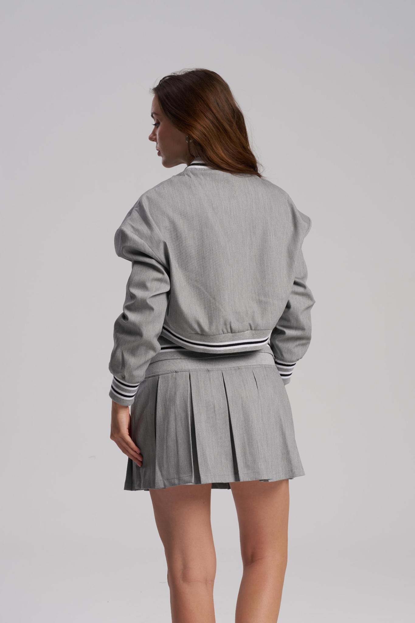 Back view of oversized jacket and pleated mini skirt set