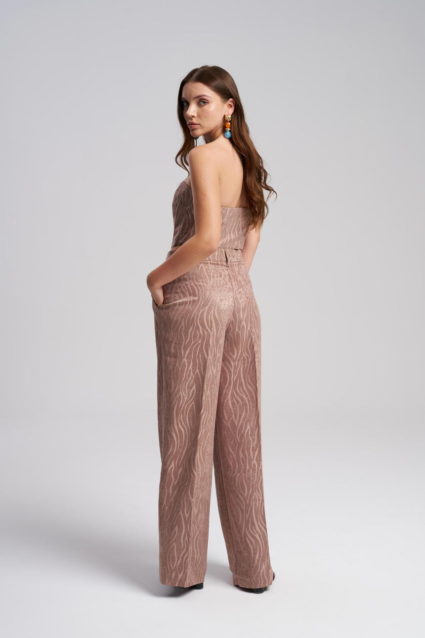 Woman wearing a patterned jumpsuit on a white background
