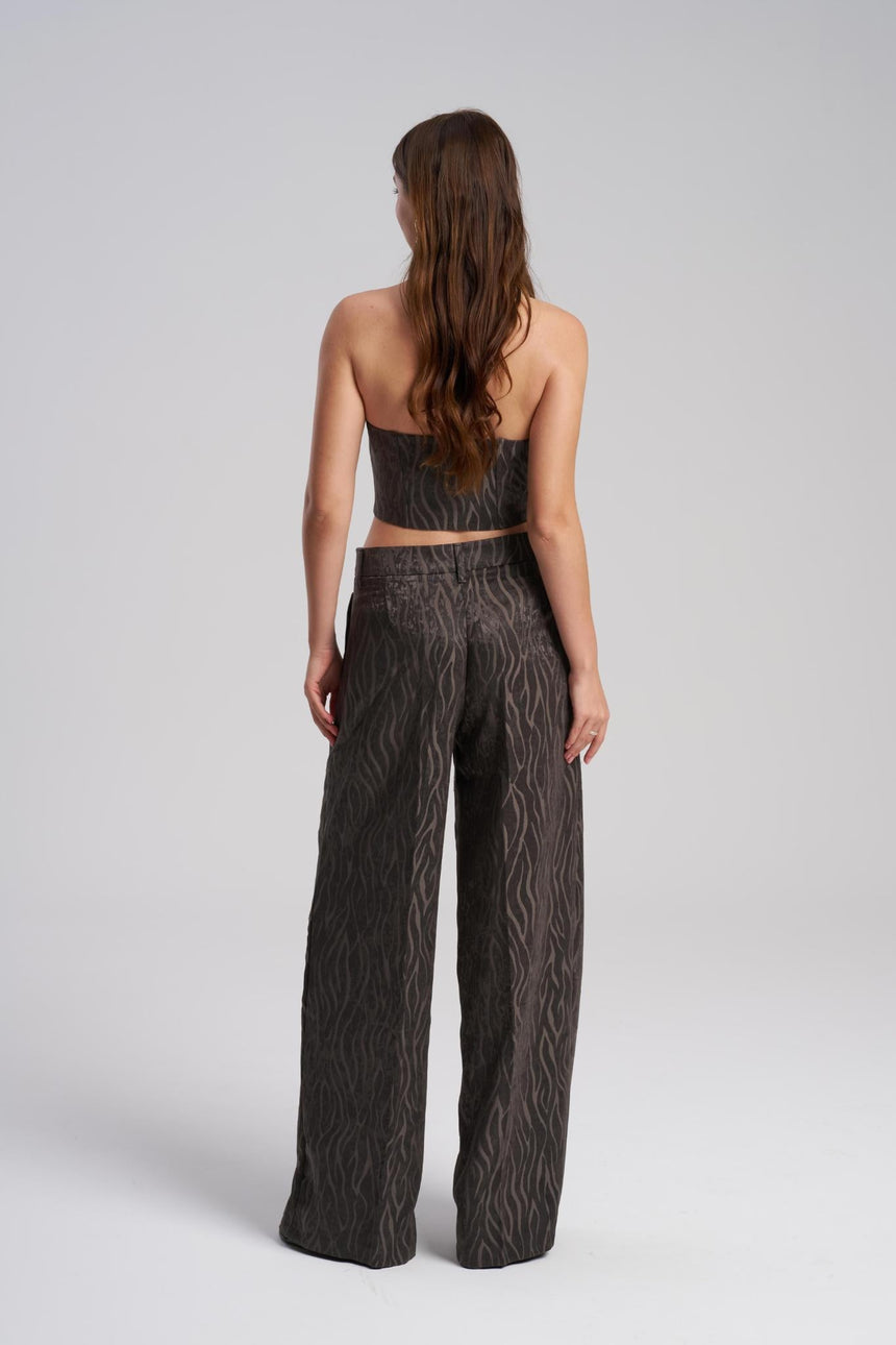 Woman wearing a matching set of top and wide-leg pants with a cable knit pattern on a white background