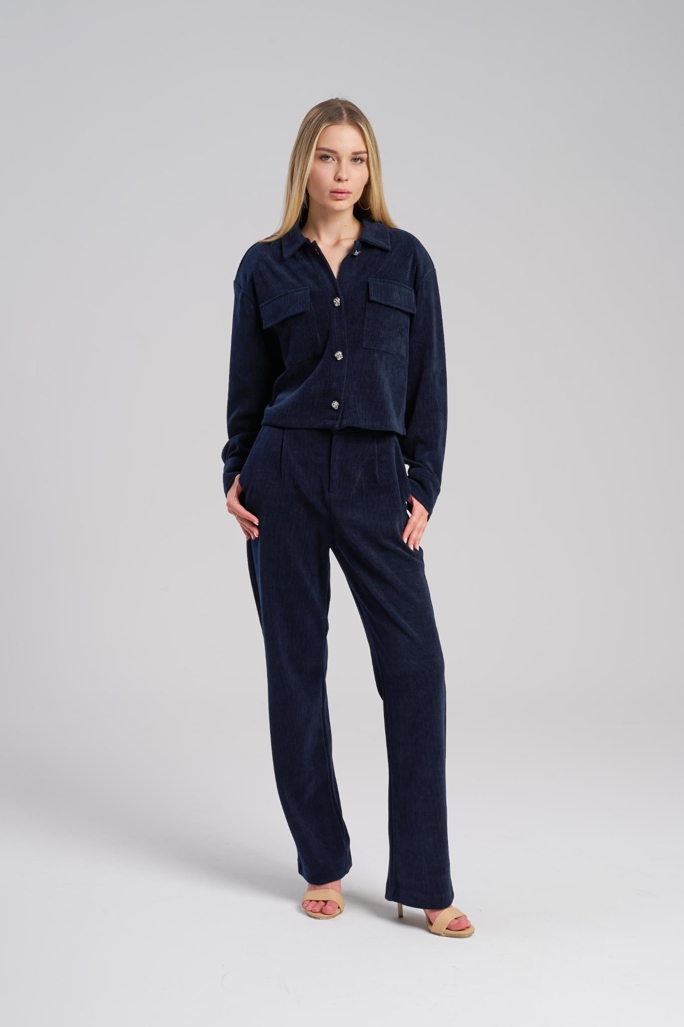 Woman wearing a navy blue outfit on a light gray background