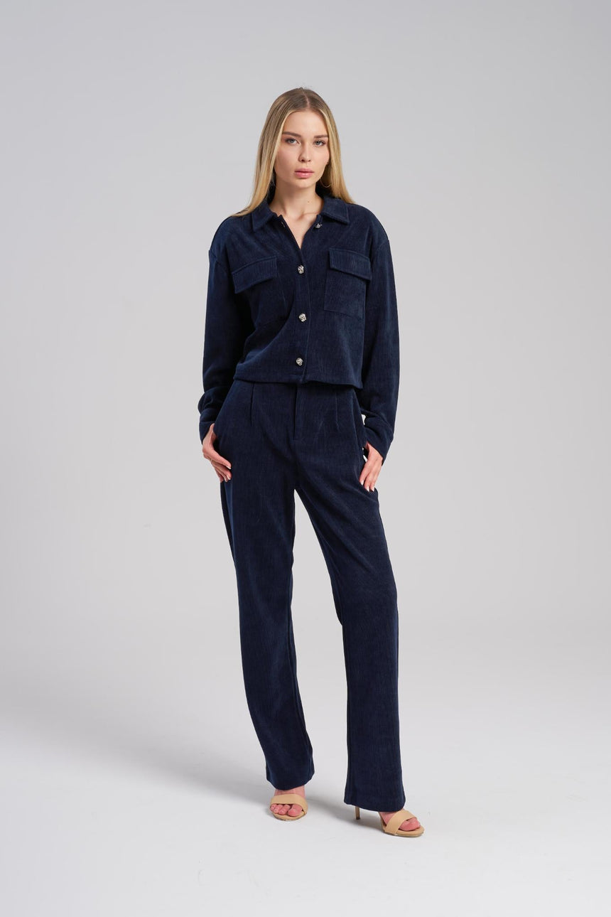 Woman wearing a navy blue outfit on a light gray background