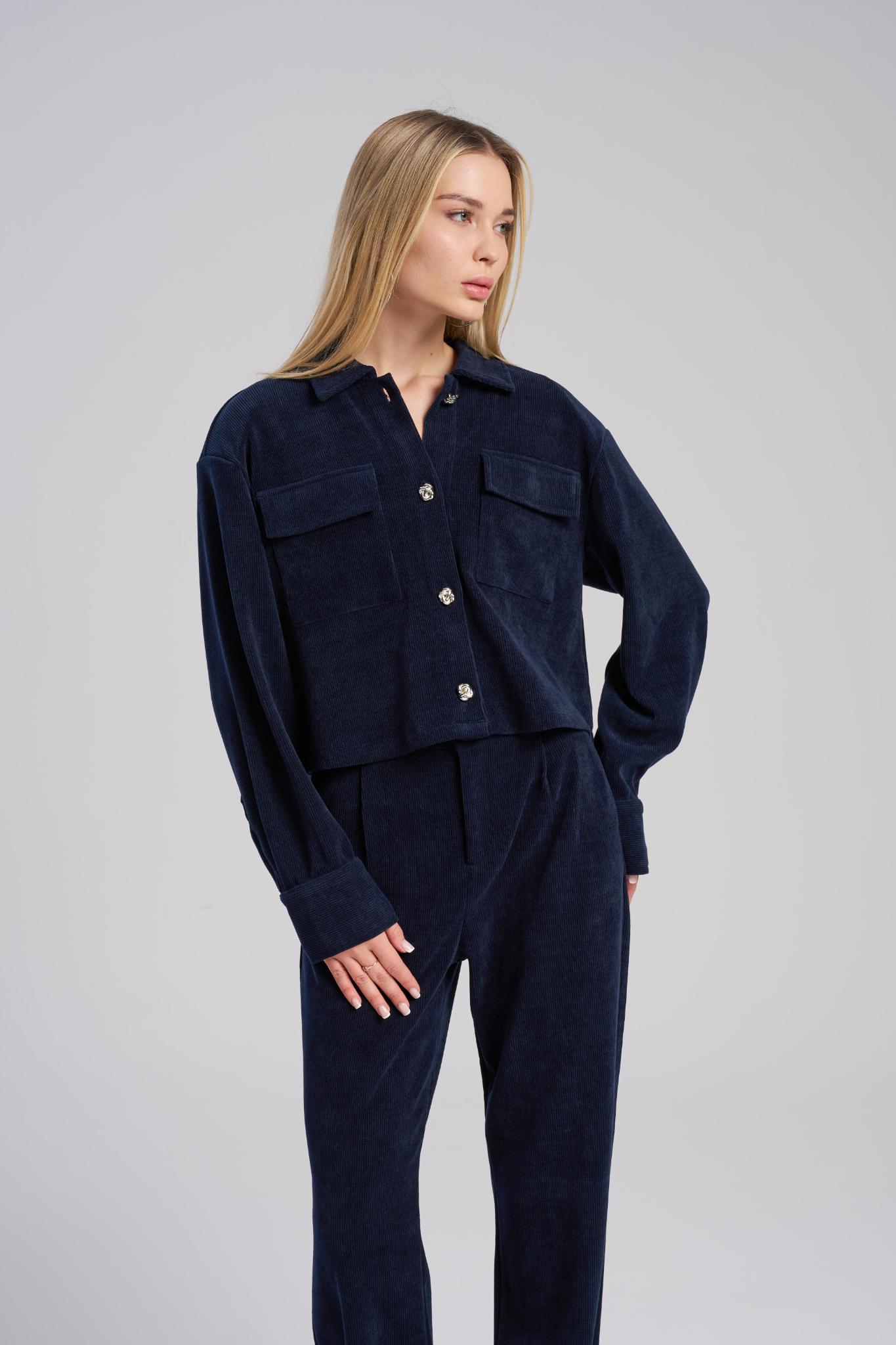 Woman wearing a navy blue outfit on a gray background