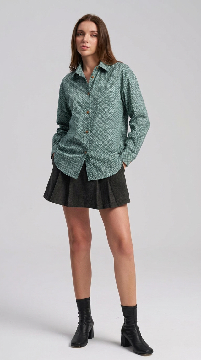 Woman wearing a green patterned shirt and black skirt on a white background