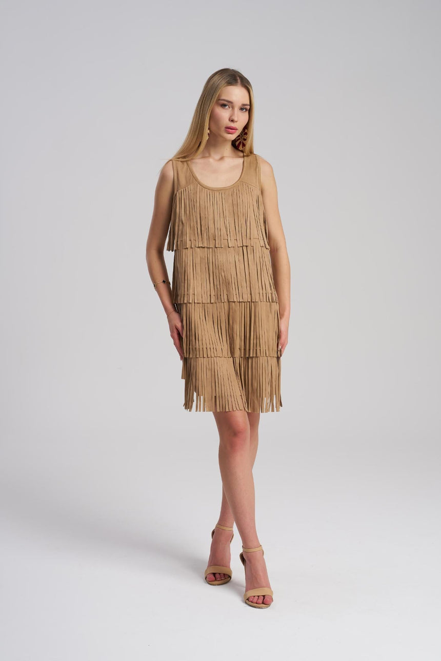 Woman wearing a beige fringe dress on a white background