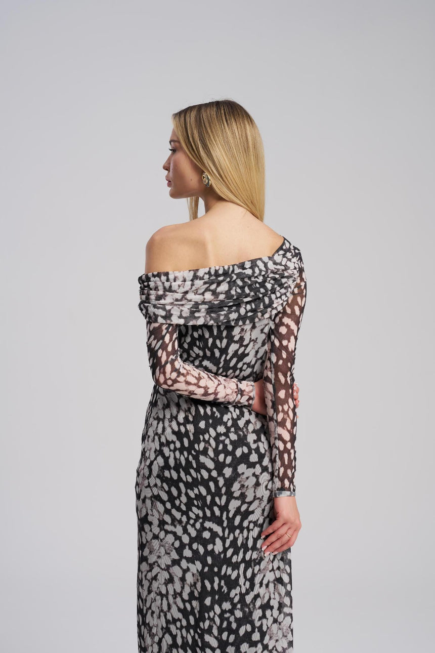 Woman wearing a patterned off-shoulder dress on a gray background