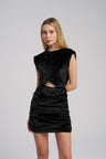 Woman wearing a black dress with cut-out design on a gray background