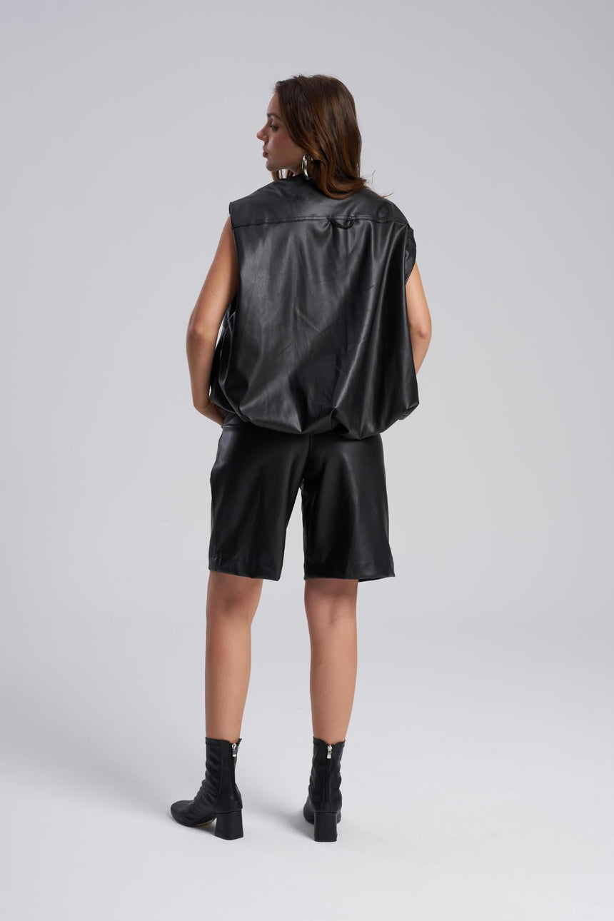 Person wearing a black sleeveless jacket and shorts set on a white background