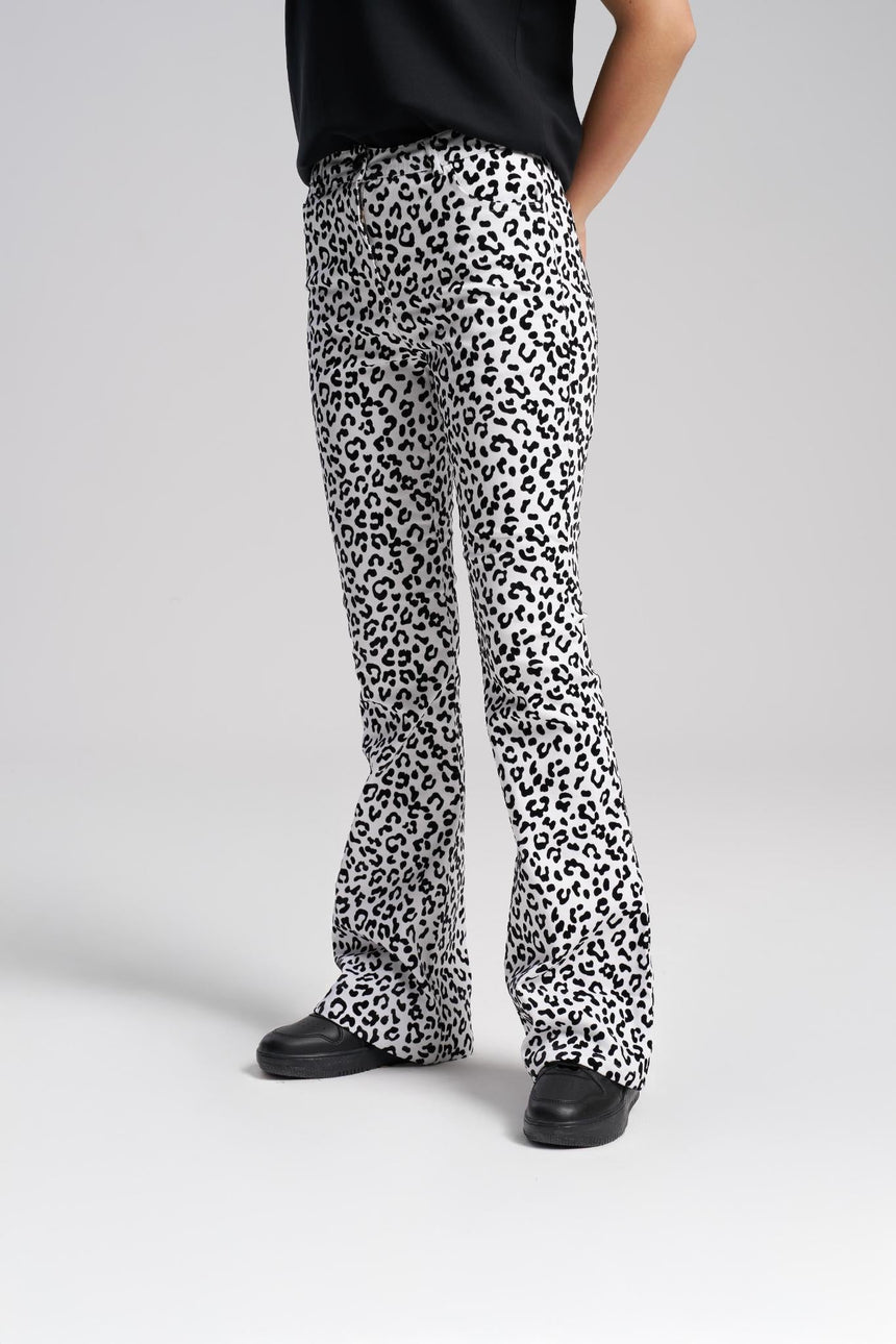 Person wearing leopard print pants on a plain background