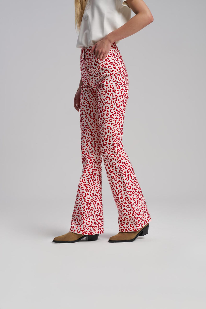 Person wearing red and white patterned pants on a plain background