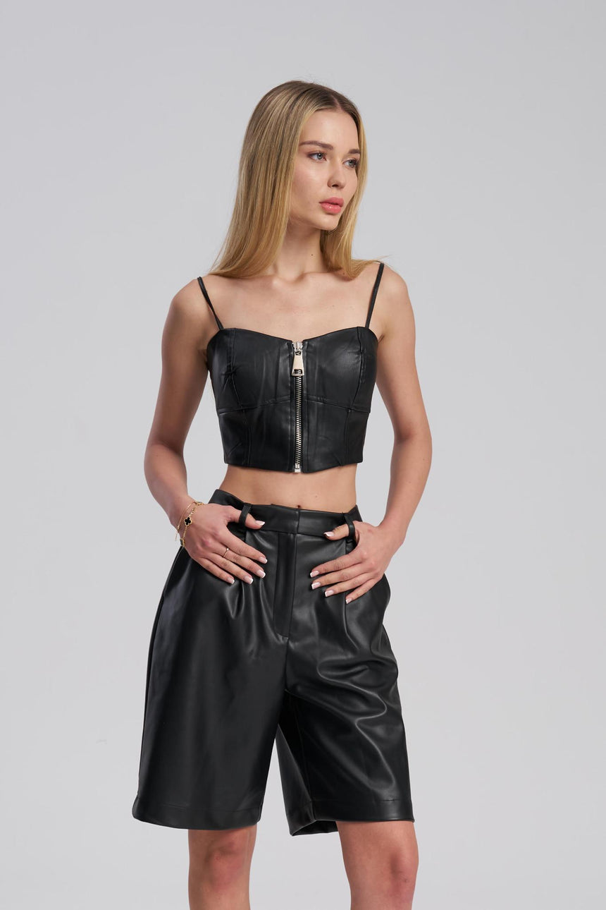 Woman wearing a black leather outfit on a gray background
