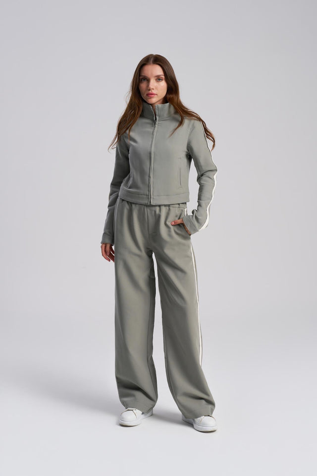 Woman wearing a gray tracksuit on a white background