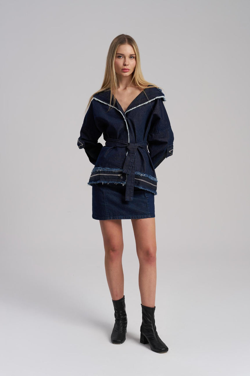 Woman wearing a navy blue outfit with a jacket and skirt on a white background