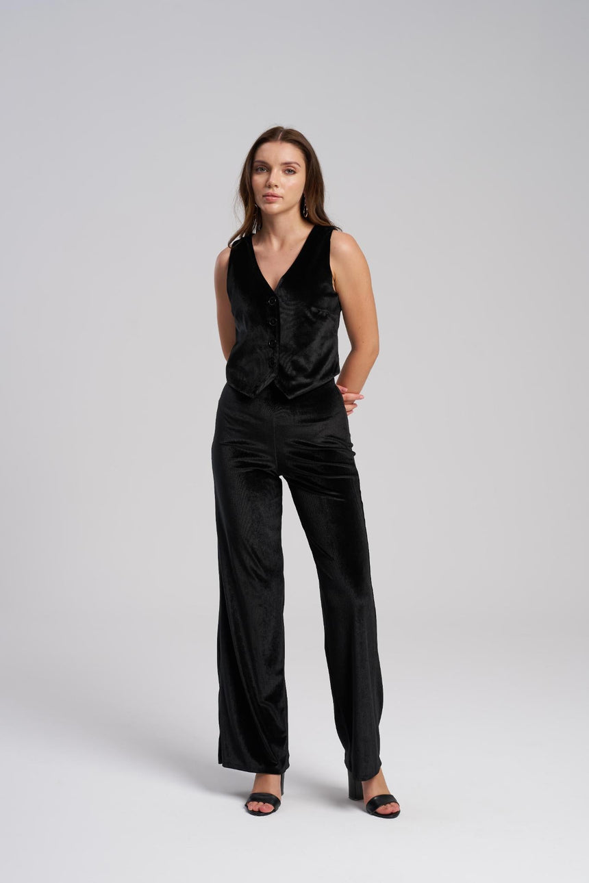 Woman wearing a black sleeveless VEST and pants on a white background